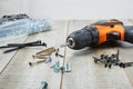 Electric screwdriver, self-tapping screws,, tool box on a wooden background
