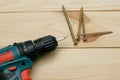 Electric screwdriver on a wooden table. Side view of the black metallic screws, electric screwdriwer on the wodden boards