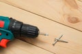 Electric screwdriver on a wooden table. Side view of the black metallic screws, electric screwdriwer on the wodden boards