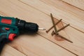 Electric screwdriver on a wooden table. Side view of the black metallic screws, electric screwdriwer on the wodden boards