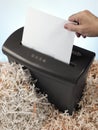 electric shredder surrounded by strips of paper