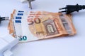 Electric sockets with euro banknotes on white background.