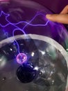 Electric sphere produce plasma with blue sparks and bolt. Science education experiment with electricity and plasma ball