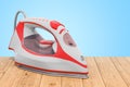 Electric steam irons on the wooden planks, 3D rendering Royalty Free Stock Photo