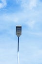 Electric street lamp against the blue sky with clouds in afternoon