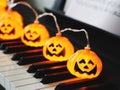 Electric string Halloween pumpkin lights on piano keyboard for Halloween party Royalty Free Stock Photo