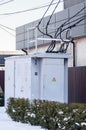 Electric substation near a private house. Gray transformer booth on the street in winter Royalty Free Stock Photo