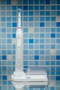 Electric toothbrush on blue tile background Royalty Free Stock Photo