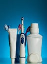 Electric toothbrush, manual toothbrushes in holder, a set of means to care for the oral cavity, on blue Royalty Free Stock Photo