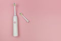 Electric toothbrush with a new head and a used one on a soft light pink background. Oral cavity home health care Royalty Free Stock Photo