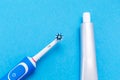 Electric toothbrush and toothpaste. Blue background. Flat lay. The concept of modern dental care products Royalty Free Stock Photo