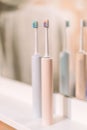 Electric toothbrushes blue and pink in front of bathroom mirror