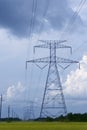 Electric tower poles on a green meadow