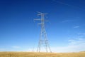 Electric tower, power tower and transmission lines in farm land in the prairies of Alberta, Canada Royalty Free Stock Photo