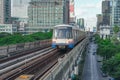 Electric train railway carriage rushes travels along route in sky railway road viaduct among the modern city of buildings,