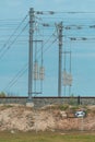 Electric train railway line tension pole with wires and concrete weights