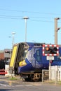 Electric train, Scotrail livery, at level crossing Royalty Free Stock Photo