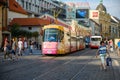 An electric tram makes its way between old buildings and tourists on the cobbled streets of the old town district of Prague Royalty Free Stock Photo