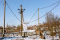 Electric transformer box on a village background. Electricity supply to the settlement. Power distribution equipment. Attention, Royalty Free Stock Photo