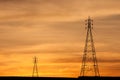 Electric Transmission Towers in orange sunset. Royalty Free Stock Photo