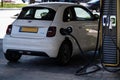 Charging a Fiat 500E with electricity at a public charging station in the Netherlands