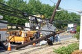 Electric utility repair crew on the scene of a broken wooden utility pole