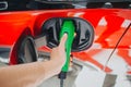 Electric vehicle charging station. Close-up of woman hand charging an electric car with the power cable supply plugged Royalty Free Stock Photo