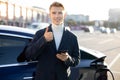 Electric vehicles charging station. Close up portrait of attractive young Caucasian man, standing near his charging Royalty Free Stock Photo