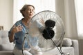 Electric ventilator cooling air blowing to senior older lady