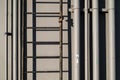 Electric and water pipelines and ladder, on industrial wall background