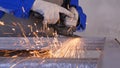 Craftsman sawing metal with disk grinder in workshop. Grinding metal with sparks flying. Electric wheel grinding on Royalty Free Stock Photo