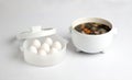 Electric white pot with soup and steamed eggs in white tray