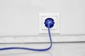 Electric white socket and one plugged in power cord on white wall background Royalty Free Stock Photo