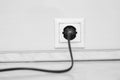 Electric white socket and one plugged in power cord on white wall background Royalty Free Stock Photo