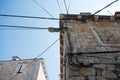 Electric wires attached on an old stone house. Old architecture. Electricity transmission. Light bulb on the building. Street ligh Royalty Free Stock Photo