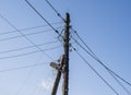 electric wires and a street lamp on an old wooden pole support against a background of blue sky with clouds Royalty Free Stock Photo