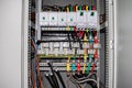 The electrical box contains many terminals, relays, wires and switches
