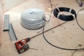 Electrical cable, wire, insulation, professional puncher with long drill, aluminum profile, construction debris on dirty tiled