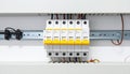 Electrical circuit breakers with yellow switches and wiring on a metal rail in a panel electrical panel Royalty Free Stock Photo