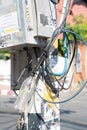 Electrical and communication cables terminate in an old drink bottle on power pole in city street.