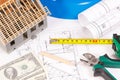 Electrical construction drawings, work tools and accessories, small house and currencies dollar, building home cost concept Royalty Free Stock Photo