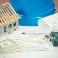 Electrical construction drawings, work tools and accessories, small house and currencies dollar, building home cost concept Royalty Free Stock Photo