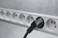 Electrical cord with power strip on grey metal background Royalty Free Stock Photo