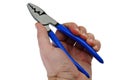 Electrical Crimping stripping pliers with blue rubber handle held in left hand of adult male person, closed jaws, white background