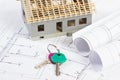 Electrical drawings, home keys and small house under construction, concept of building home cost Royalty Free Stock Photo