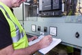 Electrical engineer in hi viz vest inspecting some circuit brteakers