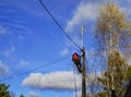 Electrical engineer holding safety helmet with electricians working on electric power pole with bucket hydraulic lifting