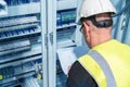 An electrical engineer reads a wiring diagram in a control cabinet Royalty Free Stock Photo