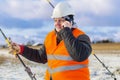 Electrical Engineer talking on cell phone near tensioner Royalty Free Stock Photo