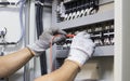 Electrical engineer tests the operation of the electric control cabinet on a regular basis for maintenance Royalty Free Stock Photo